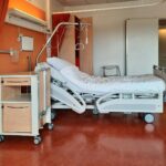 A clean and modern hospital room equipped with an adjustable bed and medical equipment.